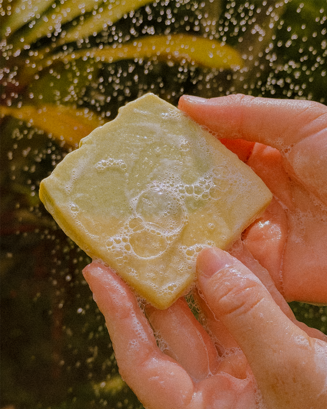 Seu Primeiro Sabonete Natural sendo segurado em mãos com espuma